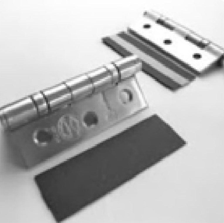 Intumescent hinge pad fitted behind a fire-rated steel hinge on a fire door