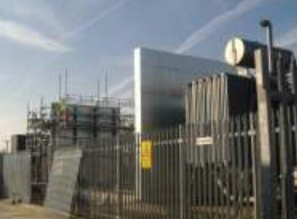 Steel composite fire barrier wall beside a transformer bay at a utility substation